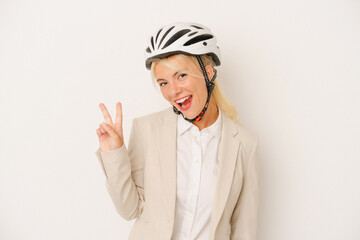 Young business Russian woman holding bike helmet isolated on white background joyful and carefree showing a peace symbol with fingers.