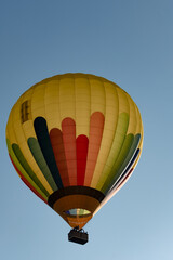 Group of people riding in a hot air balloon in the foreground and backlighting