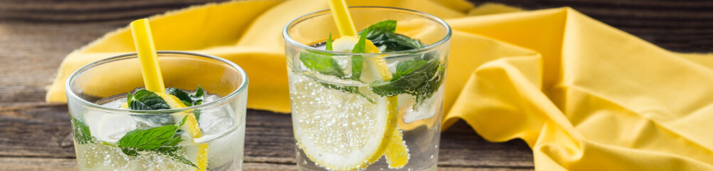 banner of Lemonade or mojito cocktail with lemon and mint with ice. Cold summer refreshing drink decorated with yellow napkin