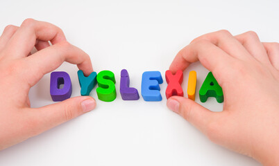 A child building the word Dyslexia out of play clay letters
