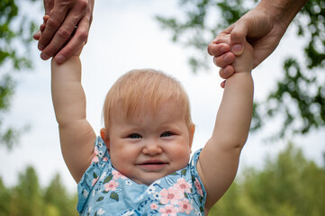 little girl holding hands of parents