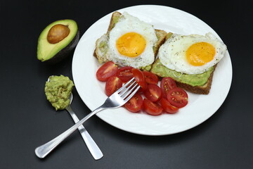 hand holding avocado, hand holding tomato cherrie, Vegetarian toast with egg and avocado, toast bread, black background