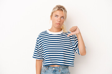 Young Russian woman isolated on white background showing a dislike gesture, thumbs down....
