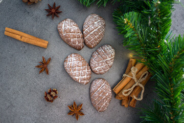 Fir tree cones shaped cookies on a table. Top view photo of chocolate biscuits, cinnamon sticks, anise stars, Christmas decoration. 