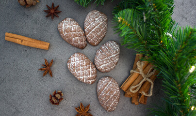 Christmas biscuits close up photo. Fir tree branches, anise stars, cinnamon sticks pine cone shaped cookies. 