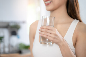 Woman smiling and holding a glass of mineral water
