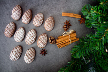 Fir tree cones shaped cookies on a table. Top view photo of chocolate biscuits, cinnamon sticks, anise stars, Christmas decoration. 