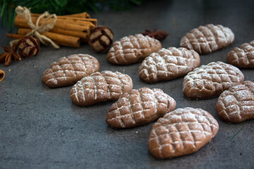 Fir tree cones shaped cookies on a table. Top view photo of chocolate biscuits, cinnamon sticks, anise stars, Christmas decoration. 