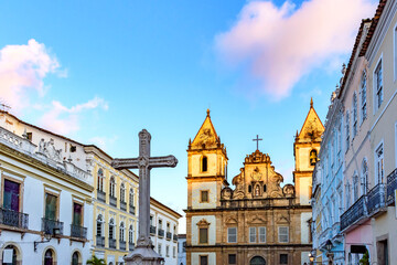 Fototapeta na wymiar Old houses and churches in colonial and baroque style with a crucifix in the central square of the historic Pelourinho district in Salvador, Bahia