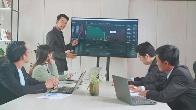 Young Asian Businessman Presentation To His Business Colleagues About Financial Chart Trading Online Investment Data On Tv Screen, Meeting Room
