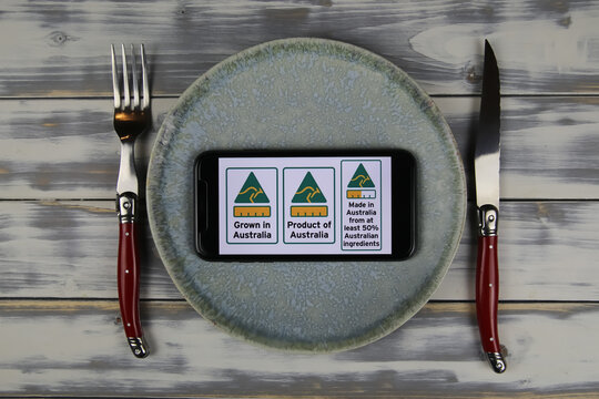 Viersen, Germany - June 9. 2021: Closeup Of Smartphone With Lettering Of Australian Made And Grown Logo On Plate With Cutlery (focus On Center)