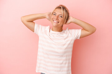 Young Russian woman isolated on pink background stretching arms, relaxed position.