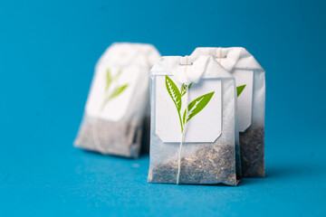 bags with green tea on a blue background.