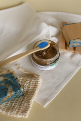 Eco wooden toothbrush, natural soap and preparing organic facial mask on white towel at home.