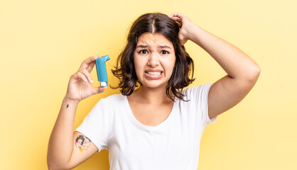 young hispanic woman feeling stressed, anxious or scared, with hands on head. asthma concept