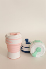 Colored silicone reusable bottles for water or drinks in light background.