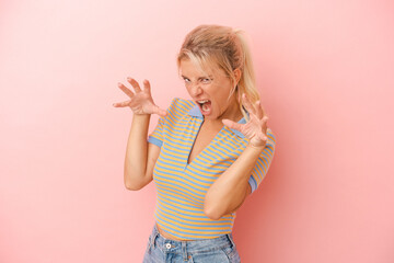 Young Russian woman isolated on pink background upset screaming with tense hands.
