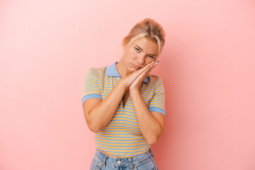 Young Russian woman isolated on pink background yawning showing a tired gesture covering mouth with hand.