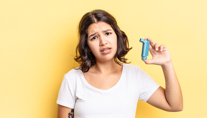 young hispanic woman feeling puzzled and confused. asthma concept