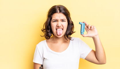 young hispanic woman feeling disgusted and irritated and tongue out. asthma concept