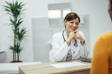 Smiling doctor listening to a patient. Good news concept.