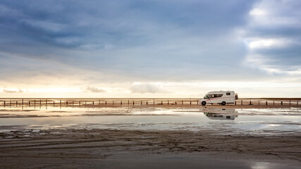 Camper van parked on the beach. Family vacation with caravan. North sea coast, Germany.