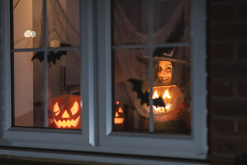 Woman witch carrying a pumpkin for Halloween night - Spooky scene with halloween symbols and signs ...
