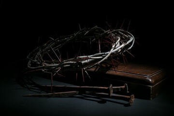 Crown of thorns and nails on a dark background - the symbols of crucifixion