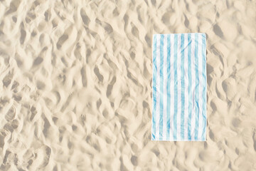 Striped beach towel on sand, aerial view. Space for text - obrazy, fototapety, plakaty