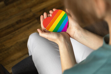 Hands with LGBT rainbow symbol. Colorful heart close-up. LGBTQ, lesbian and gay rights, pride month and tolerance background photo