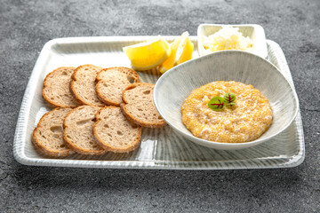 Pike caviar, butter with crispy croutons and lemon appetizer. Ready menu for the restaurant. Neutral gray blue textured background