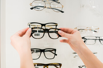 Vision health, blindness, and vision impairment concept. Close-up of woman choosing glasses on...
