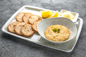 Pike caviar, butter with crispy croutons and lemon appetizer. Ready menu for the restaurant. Neutral gray blue textured background