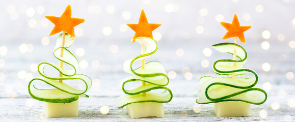 banner of Creative set christmas trees of cucumber, cheese and star of carrot. Funny kids food for new year party