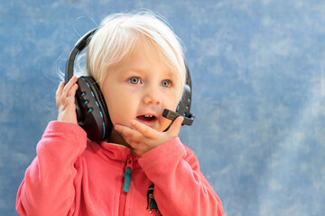A child playing with headphones talks to the players through the built-in microphone in the...