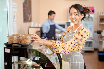 A beautiful woman bakery or coffee shop owner is smiling in her shop