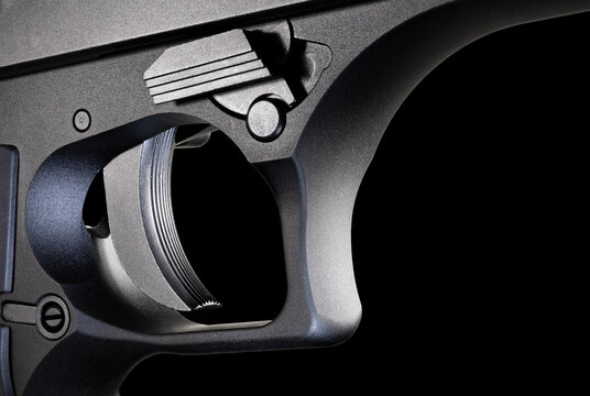Metal framed handgun trigger that is on a black background