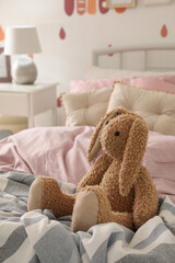 Toy bunny on bed in child's room. Interior design