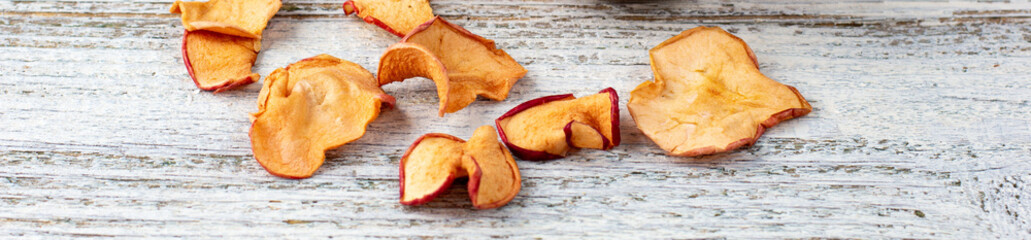 banner of A pile of dried slices of apples and fresh ripe apples on wooden background.