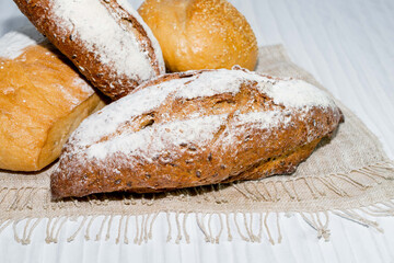 different bread round baguette isolated on white wood background, rustic crusty bun top view, food and drink concept.