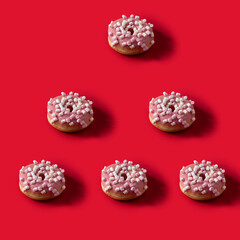 Fototapeta na wymiar Pink donut with marshmallow topping on redbackground .Modern pattern