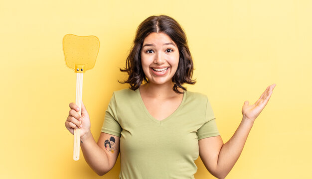 Young Hispanic Woman Feeling Happy And Astonished At Something Unbelievable. Kill Flies Concept