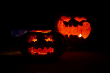 two carved pumpkins with a candle in the dark for halloween
