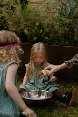 Twin girls with Down Syndrome playing with water and paint powder outdoors