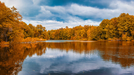 Autumn landscape of lake and reflection of forest trees in water