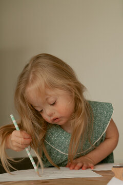 Little girl with Down Syndrome drawing