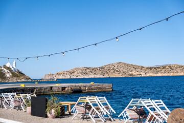 Greek outdoors cafe restaurant tavern at seaside, Ios island, Cyclades, Greece. - obrazy, fototapety, plakaty