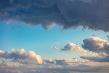 Fluffy cumulus clouds on blue sky background. Cloudscape white and grey color