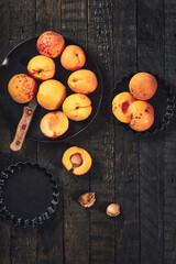 Ripe apricots on dark wood.