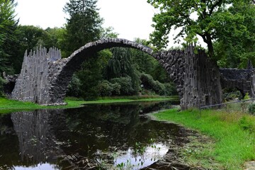 Fototapeta na wymiar stone bridge on the river in the forest